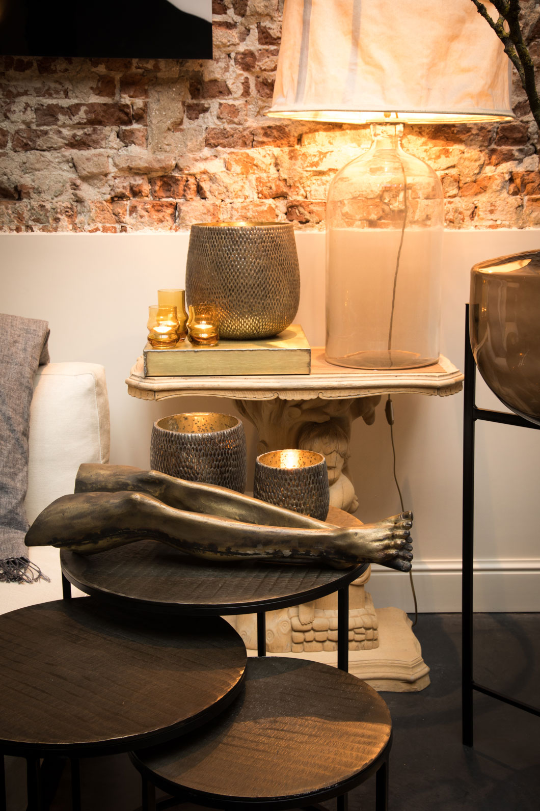 Various sizes of rice-mosaic patterned vases on top of a set of nested round side tables.